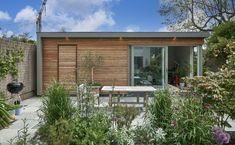 a small wooden house surrounded by plants and flowers