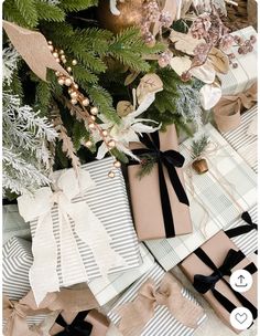 presents wrapped in brown paper and tied with black ribbon are sitting next to a christmas tree