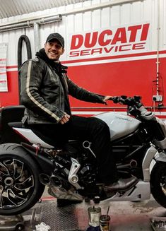 a man sitting on top of a motorcycle in a garage