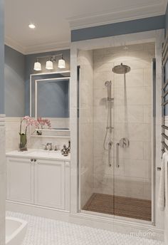 a bathroom with a walk in shower next to a sink and a bathtub filled with white towels