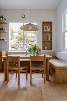 a dining room table with two chairs and a bench in front of a large window