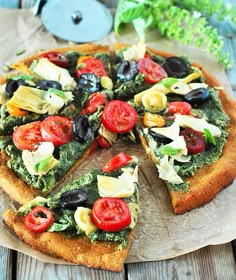 a close up of a pizza with toppings on a wooden table next to vegetables