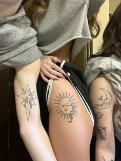 two girls with sun and moon tattoos on their backs, one girl has her arm around the other