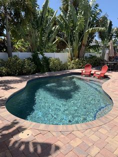 the pool is surrounded by palm trees and lawn chairs, which are also in red