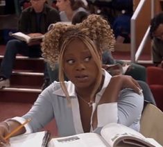 a woman sitting at a table with an open book in front of her and looking surprised