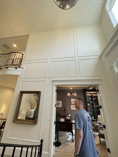 a man walking into a room with white walls