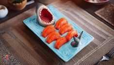 there is a blue plate with some fish on it and a shark's mouth