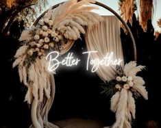 a wedding arch decorated with feathers and flowers