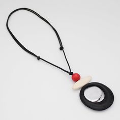 "Transform any outfit into a work of art with our Silver Accent Reese Pendant. This statement piece features a unique combination of black and red tone wooden discs, elevated by a sleek silver accent. Lightweight and funky, it adds an artistic touch to your style.  Adjustable Length: 22\"-34\" Care Instructions: Remove jewelry when applying perfumes, creams, washing hands etc. Do not store in direct sunlight. to restore color and shine apply a drop of oil with a soft cloth" Modern Black Necklace With Large Pendant, Black Minimalist Necklace With Large Pendant, Minimalist Black Necklace With Large Pendant, Modern Black Round Pendant Necklace, Red Tone, Washing Hands, Necklace Wood, Black Pendant, Wood Pendant