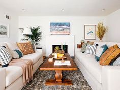 a living room with two couches and a coffee table in front of a fireplace