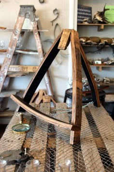 a wooden frame sitting on top of a table in a room filled with shelves and ladders