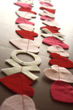 some red and white hearts are hanging on a table