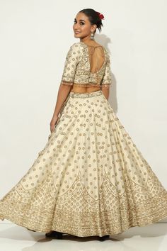 Ivory and gold kalidar lehenga with all over Padma bagh motif embroidery using zardozi highlights and tassel ornamentation. Paired with an elbow sleeves floral jaal embroidered leaf neck blouse with dangling glass beads hem and a bloom border embroidered dupatta. - Aza Fashions Elegant Semi-stitched Gota Work Choli, Elegant Semi-stitched Choli With Gota Work, Beige Embroidered Reception Set, Elegant Navratri Choli With Gota Work, Elegant Gota Work Choli For Navratri, Cream Sets With Resham Embroidery For Reception, Elegant Beige Choli With Traditional Drape, Elegant Raw Silk Lehenga With Gota Work, Elegant Lehenga With Gota Work In Raw Silk