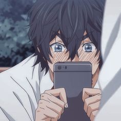 an anime character is looking at his cell phone and holding it up to the camera