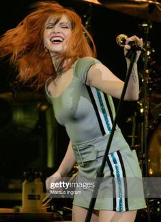 a woman with red hair singing on stage