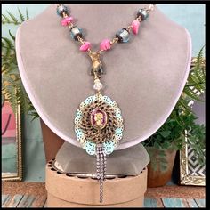 Bj Adorned Crown Assemblage Statement Necklace Original Design Necklace Assembled Using A Vintage Glass Intaglio Cameo Mounted On A Gold Tone And Teal Filigree Background. I’ve Assembled The Chain With A Vintage Natural Patina Brass Hand Charm Holding The Pendant And Hung From Wire Wrapped Pink Howlite Stone Beads And Faceted Glass Beads. Measures 21” Long With An Asymmetrical Side Closing Hook And Eye Clasp Pendant Measures 2” Assemblage Jewelry Is Made Using Pre-Loved Pieces Of Jewelry, Toys, Artisan Pink Necklace With Colorful Beads, Artisan Pink Beaded Necklace For Festivals, Unique Pink Beaded Necklaces For Festival, Unique Pink Beaded Necklace For Festival, Unique Pink Necklace For Festivals, Elegant Pink Necklaces For Festivals, Pink Handmade Beaded Necklaces, Elegant Pink Beaded Necklace For Festival, Unique Pink Beaded Necklace For Party