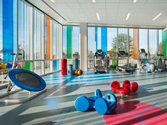 an indoor gym with exercise equipment and windows