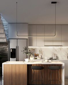 a modern kitchen with marble counter tops and wooden stools next to the stairs that lead up to the second floor