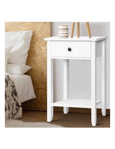 a white bedside table with two drawers on each side and one drawer at the top