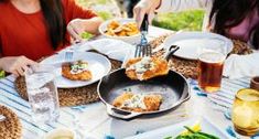 people sitting at a table with food and drinks