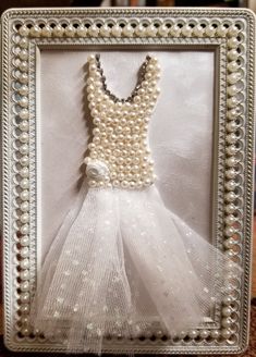 a dress made out of pearls in a frame