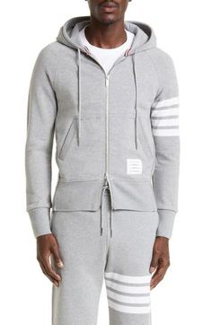 Engineered stripes at the left sleeve play up the sporty look of a cotton French terry hoodie featuring ribbed side panels for enhanced comfort and mobility. Tricolor aglets and a name tag at the hem are customary Thom Browne touches. 26" length (size 2) Drawstring hood Two-way front-zip closure Split kangaroo pocket Ribbed cuffs and hem 100% cotton Dry clean or hand wash, dry flat Made in Japan Sporty Double-lined Hood Sweats For Spring, Sporty Spring Sweats With Double-lined Hood, Cotton Sportswear Hoodie With Ribbed Waistband, Sporty Hoodie Sweatshirt With Ribbed Waistband, Cotton Sportswear Hoodie With Three Stripes Branding, Sporty Cotton Hoodie With Three Stripes, Cotton Sports Sweatshirt With Contrast Stripes, Cotton Sweatshirt With Contrast Stripes For Sports, Casual Winter Sweatshirt With Signature Stripes