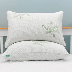 two pillows sitting on top of a white bed