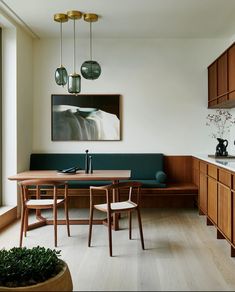 a dining room table and chairs in front of a painting on the wall next to a window