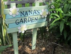 a wooden sign that says nan's garden with flowers on it