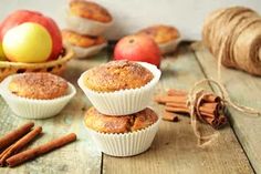 muffins with cinnamon, apples and cinnamon sticks on wooden table