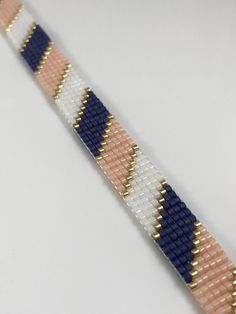 the beaded bracelet is made with different colors and sizes, including blue, white, pink