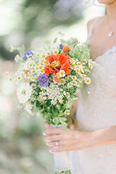 a woman holding a bouquet of flowers in her hands