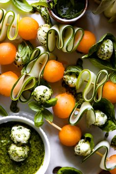 an assortment of vegetables on skewers with pesto sauce