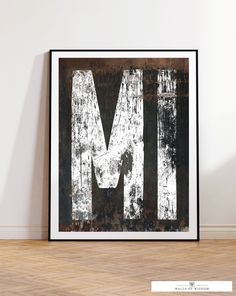 the letter m is made up of white paint on an old metal sheet and black frame