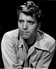 a black and white photo of a man with his arms crossed looking at the camera