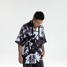 Experience the perfect fusion of street style and casual comfort with our Dragon Calligraphy Cuban Half Shirt. This shirt features an all-over print of calligraphy artwork, exuding a unique and edgy street vibe. The addition of ink splatter prints adds depth and character to the design. A single pocket adorns the left chest, offering both style and functionality. With half sleeves and a Cuban collar, this shirt strikes the perfect balance between modern and retro aesthetics. Crafted from premium Hip Hop Style Graffiti Print Tops For Spring, Hip Hop Tops With Graffiti Print For Spring, Spring Hip Hop Graffiti Print Tops, Casual Graffiti Print Streetwear Shirt, Casual Graffiti Print Shirt For Streetwear, Casual T-shirt With Abstract Print, Streetwear Graphic Print Shirt For Spring, Trendy Cotton Shirt With All Over Print, Spring Casual Hawaiian Shirt With Graphic Print