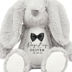 a gray bunny rabbit with a bow tie on it's chest, sitting in front of a white background