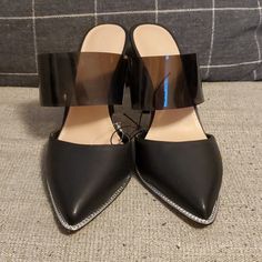 Black Slip On Heels. Plastic Strap And Metal Accents Inthe Front. Brand New, Never Worn - No Box. Trendy Mules With Contrasting Heel Counter For Party, Trendy Mules With Contrasting Heel For Party, Black Mules With Contrasting Heel Counter For Evening, Evening Black Mules With Contrasting Heel Counter, Sleek Party Mules With Block Heel, Trendy Black Mules For Party, Trendy Black Party Mules, Synthetic Pointed Toe Mules For Night Out, Black Closed Toe Mules For Party