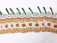 several pieces of fabric with pumpkins and leaves on them are lined up in rows