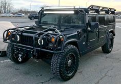 a black hummer is parked in a parking lot