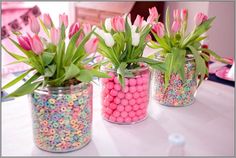 three vases with flowers and candy balls in them