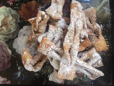 powdered sugar covered pastries and flowers on a table