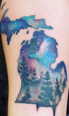 a watercolor tattoo with the shape of a bear's head and trees on it