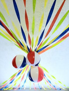 colorful streamers are hanging from the ceiling in front of balloons that look like sunbursts