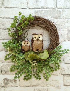 two owls sitting on top of a wreath