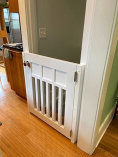 an open white door in the middle of a wooden floor