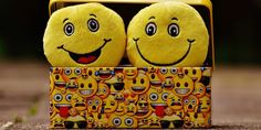 two yellow smiley faces sitting in a box