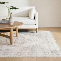 a living room with a white couch and wooden coffee table