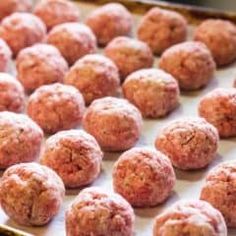 raw meatballs on a baking sheet ready to be cooked in the oven for consumption