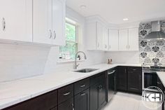 a kitchen with white counter tops and black cabinets